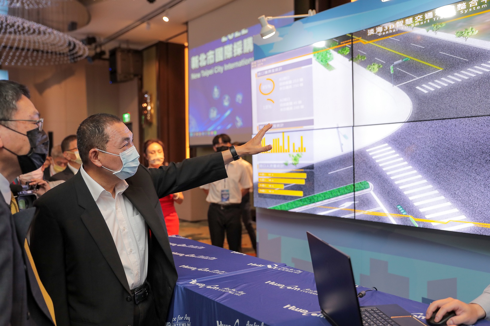 侯友宜市長在活動現場率先體驗華電聯網所展示的商品，以數位分身技術體驗淡海C-ITS場域3D平台，感受智慧道路管理方式